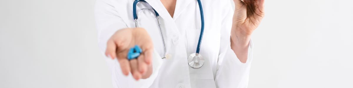 Veterinário a segurar comprimidos na mão, representando a importância da suplementação e das terapias naturais no alívio da ansiedade em cães e gatos